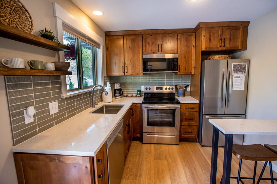 Kitchen photo with dishawasher, fridge, drip coffee maker, and breakfast bar.jpg