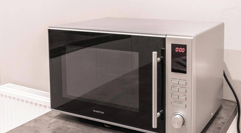 Comfortable communal kitchen with fridge and microwave for light cooking.