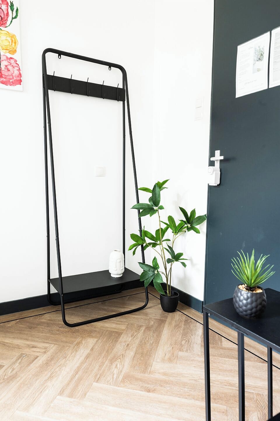 Welcome simplicity and nature into your space at Bed and Coffee Central with our sleek coat rack, beautifully accented with vibrant greenery—creating a refreshing, minimalist touch.