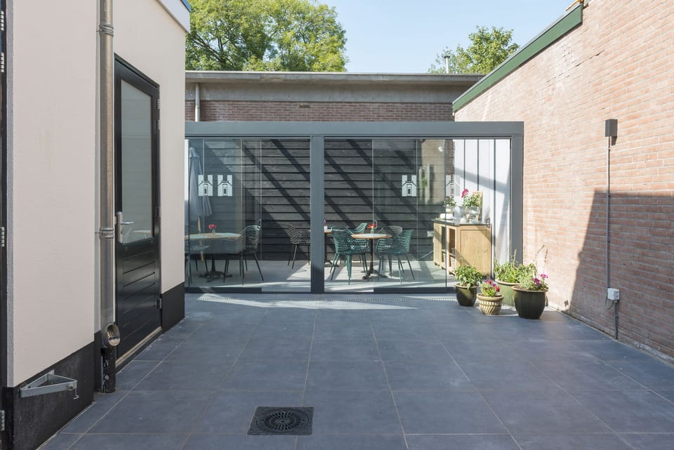 A modern courtyard entrance showcasing a spacious and inviting pathway leading to contemporary residences.

Stadskamer met knusse sfeer nabij Poppodium 013