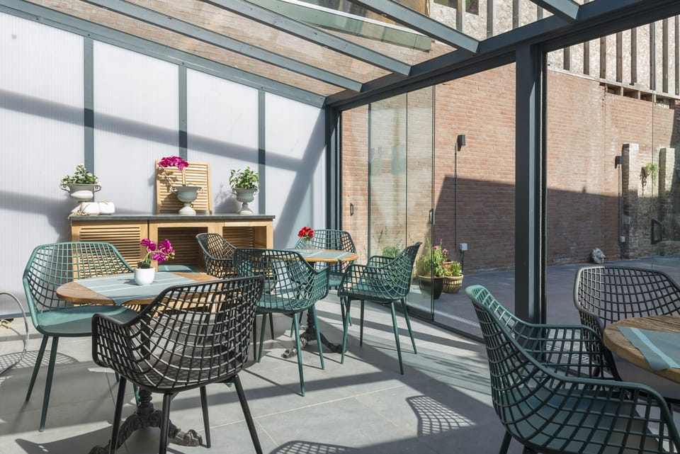 Bask in the sunlight in our shared garden, where vibrant chairs and fresh flowers make every moment special.

Budgethotel met toegang tot rustige tuin.