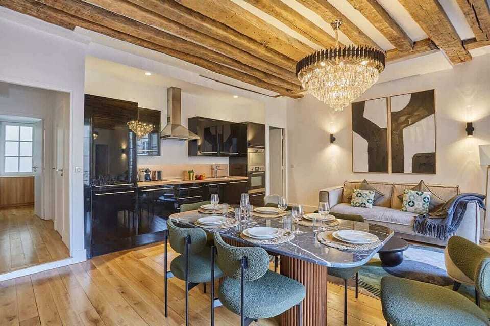 Superbe séjour avec grande table pour dîner et canapé lit et cuisine américaine équipée
