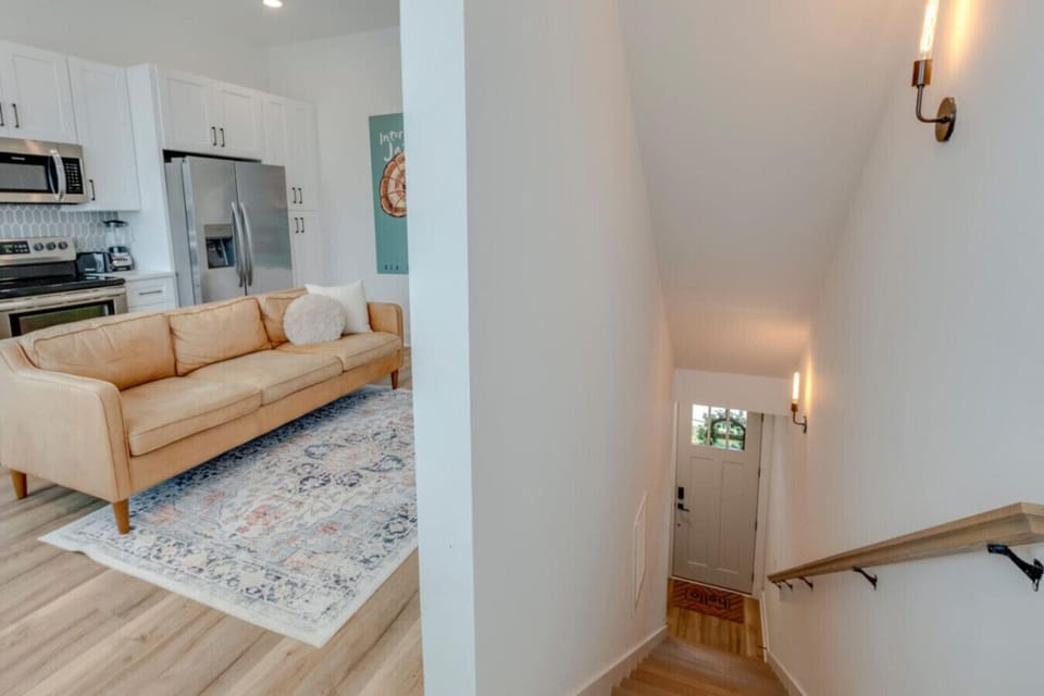The main floor living area with a large TV and blue accent wall provides a stylish group lounge space.