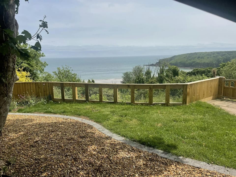 Secure garden with lawn and gravel area and sea views