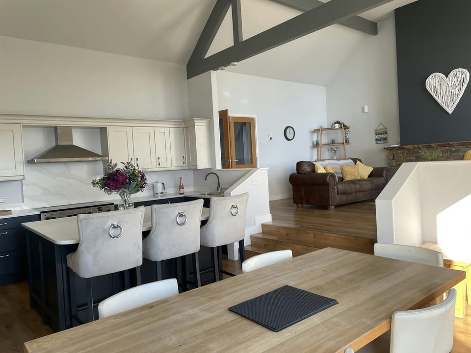 Open plan kitchen/diner, dining table, kitchen island with three bar stools