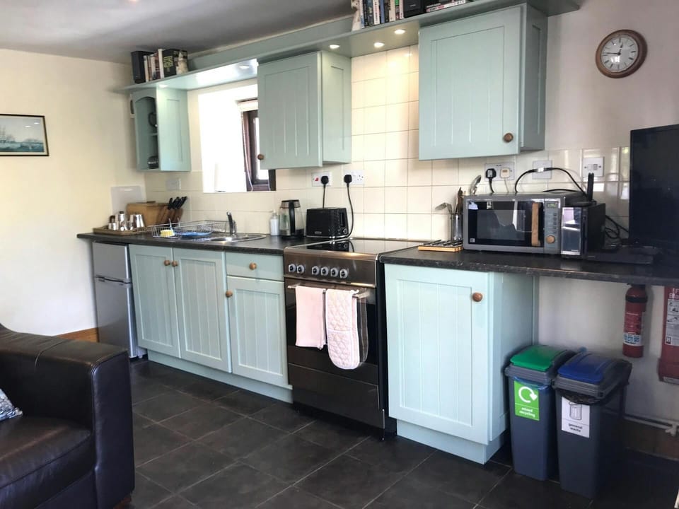 Kitchen with electric cooker, fridge, microwave, kettle and toaster