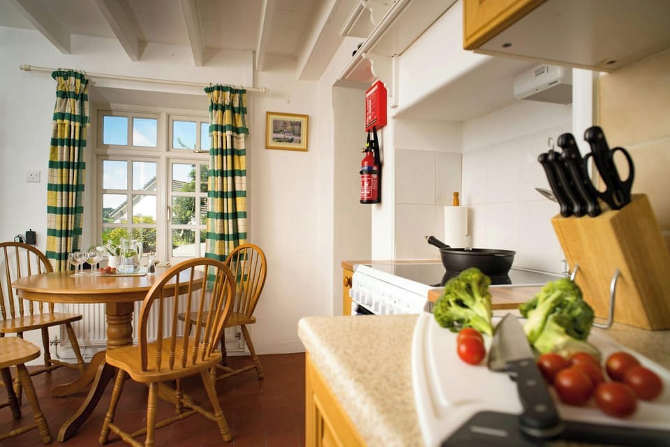 Table and chairs next to window in the kitchen at Garden Cottage