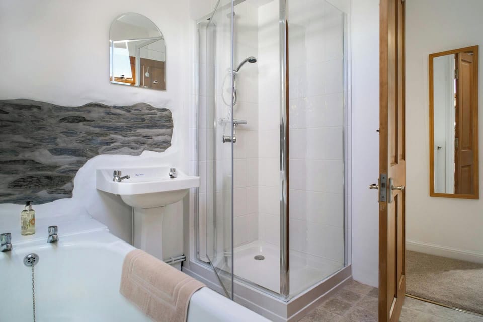 Bath, shower cubicle, wash basin with mirror above