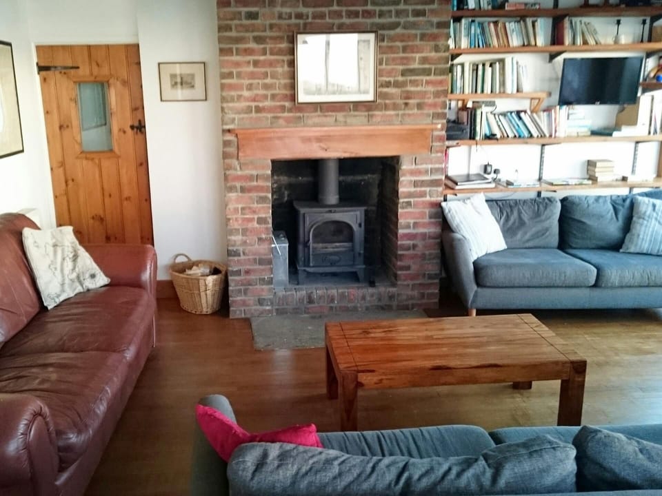 Sitting area with wood burner, two sofas, TV and coffee table