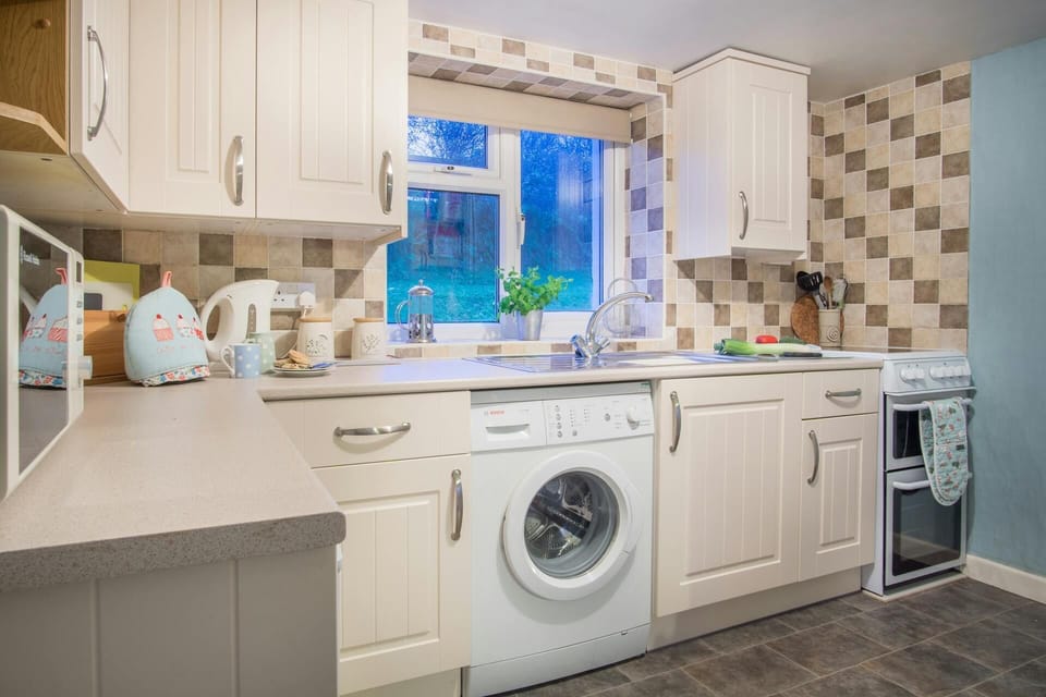 Kitchen with and electric stove, microwave, ketlle and washing machine