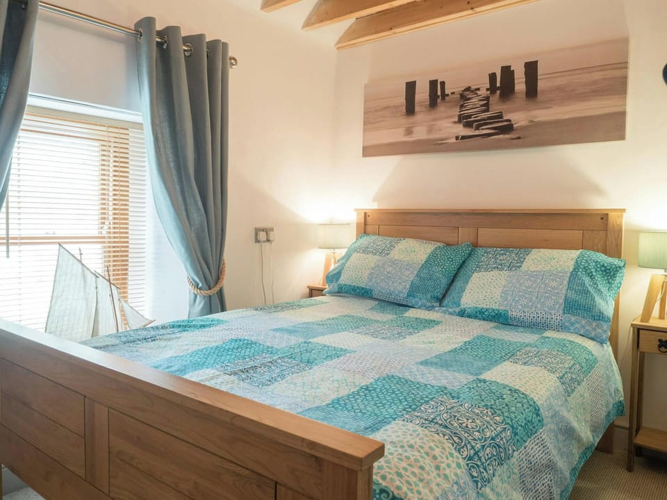 King size bed, bedside tables with lamps and large art above the bed