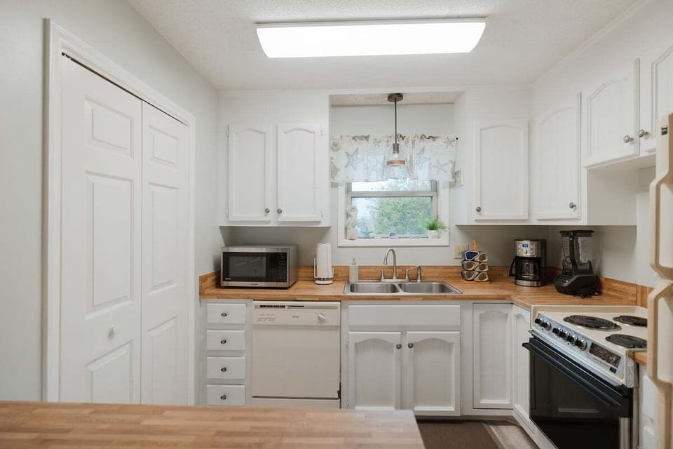 Fully stocked kitchen featuring modern appliances, cookware, and everything you need for effortless vacation meals. Includes garbage disposal, full‑size fridge, and plenty of counter space.