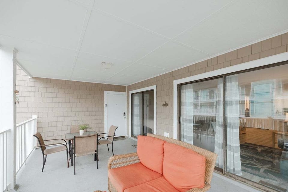 Spacious primary bedroom with plush bedding, natural light, and private bathroom access. A peaceful retreat for restful nights after exploring Carolina Beach