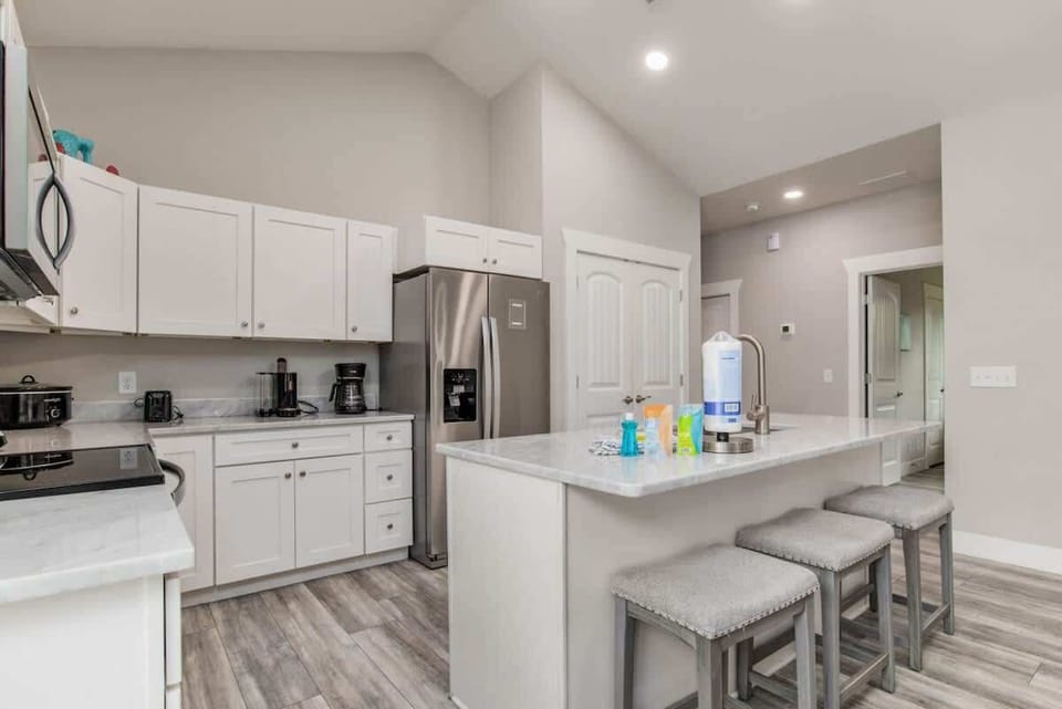 Full living room, with flat screen TV. Perfect for family vacations, or a couples getaway. Couch and loveseat. and living room attached to a kitchen with Island.