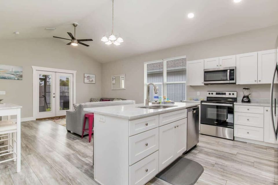 Full living room, with flat screen TV. Perfect for family vacations, or a couples getaway. Couch and loveseat. and living room attached to a kitchen with Island.