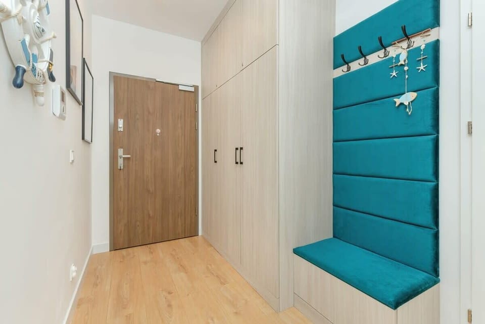  A corridor with a turquoise bench to make putting on shoes easier. 
