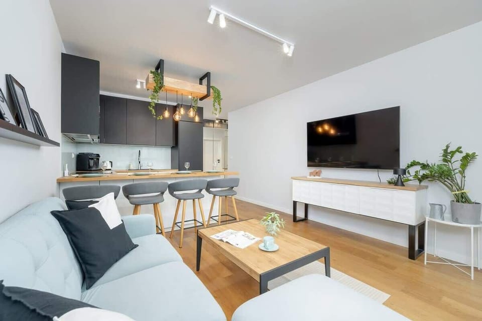 A spacious living area with designer lighting and a kitchen island invites quality time with loved ones.