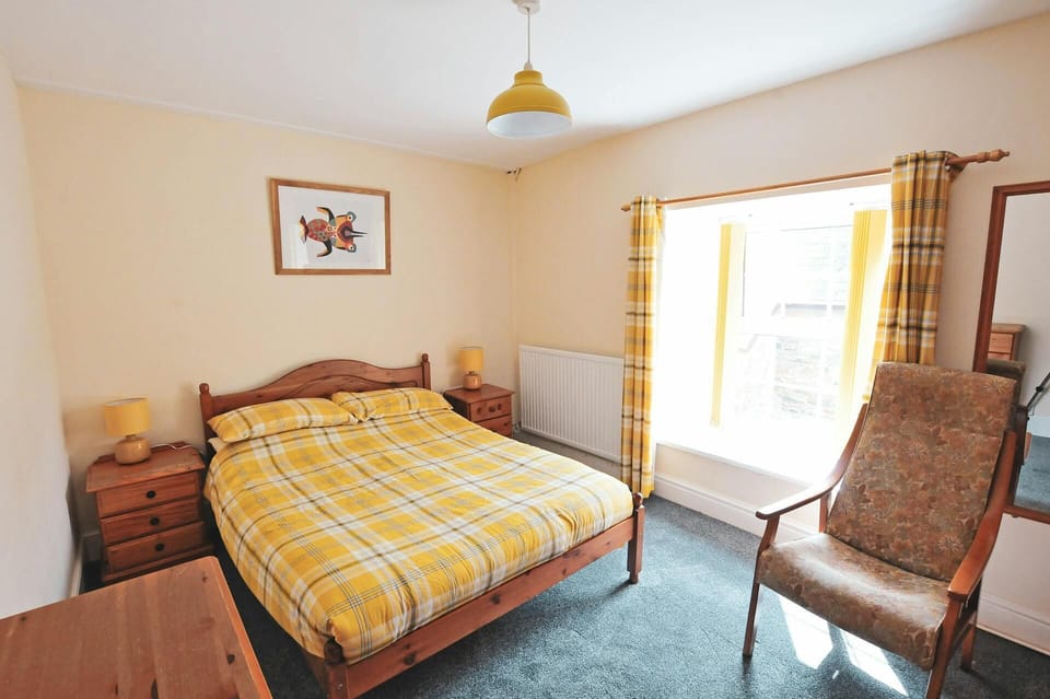 Double bed, bedside cabinets and lamps, armchair, long wall mirror