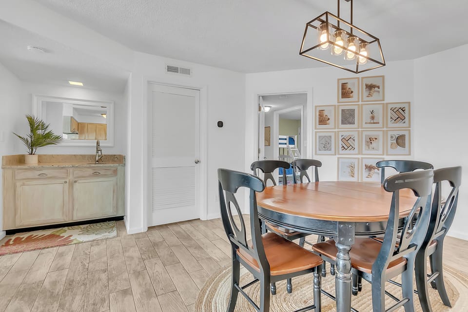 Gather around this elegant dining space where warm wood meets coastal charm, perfect for memorable meals with family.