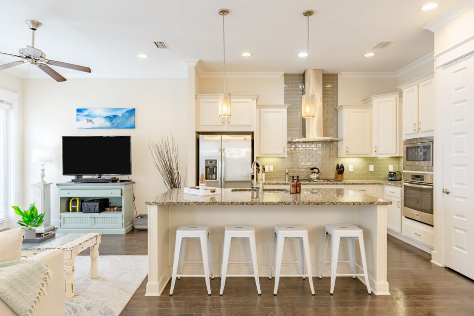 Kitchen features an island with barstool seating.