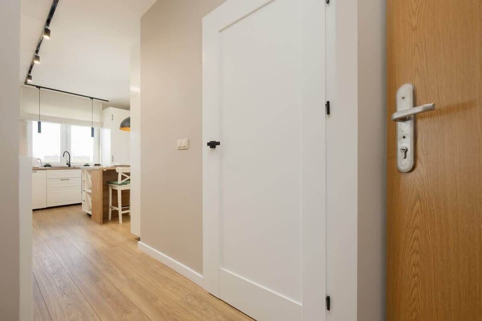 Bright hallway with wooden flooring and white walls.