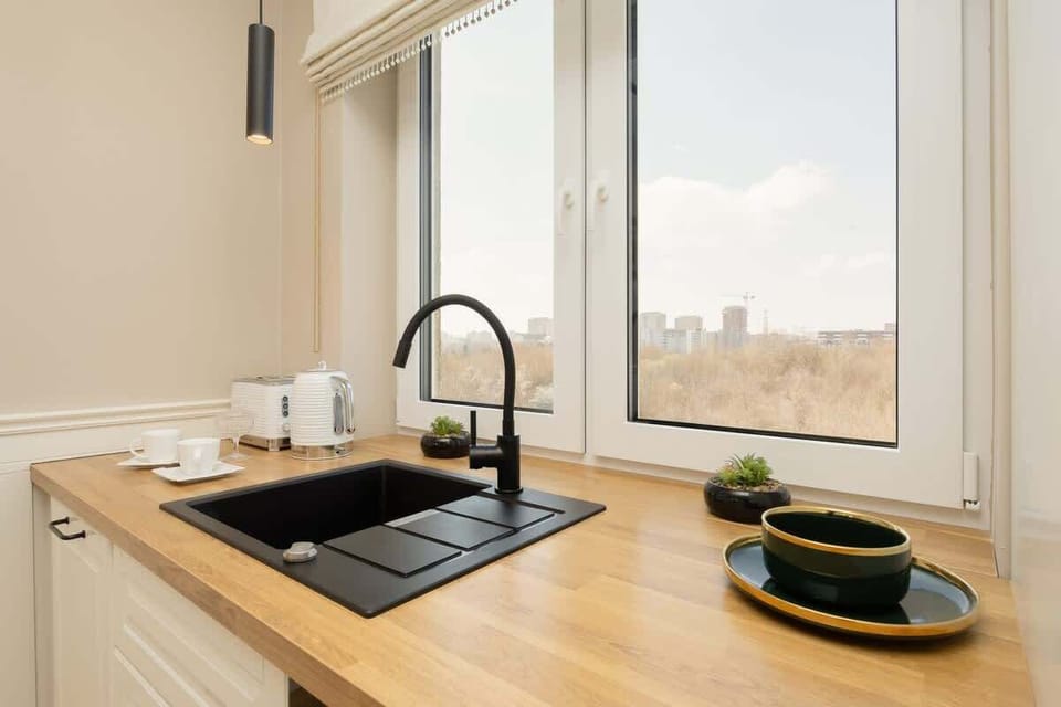 Close-up of a sink and window looking out into the open sky.