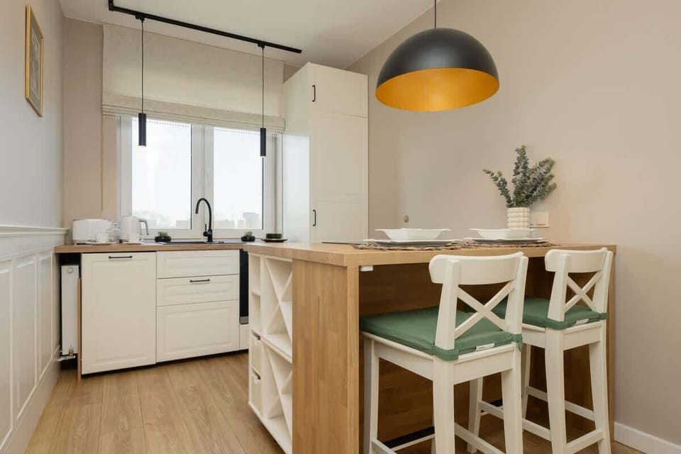 Dining room and kitchenette with a neatly set table under warm lighting.