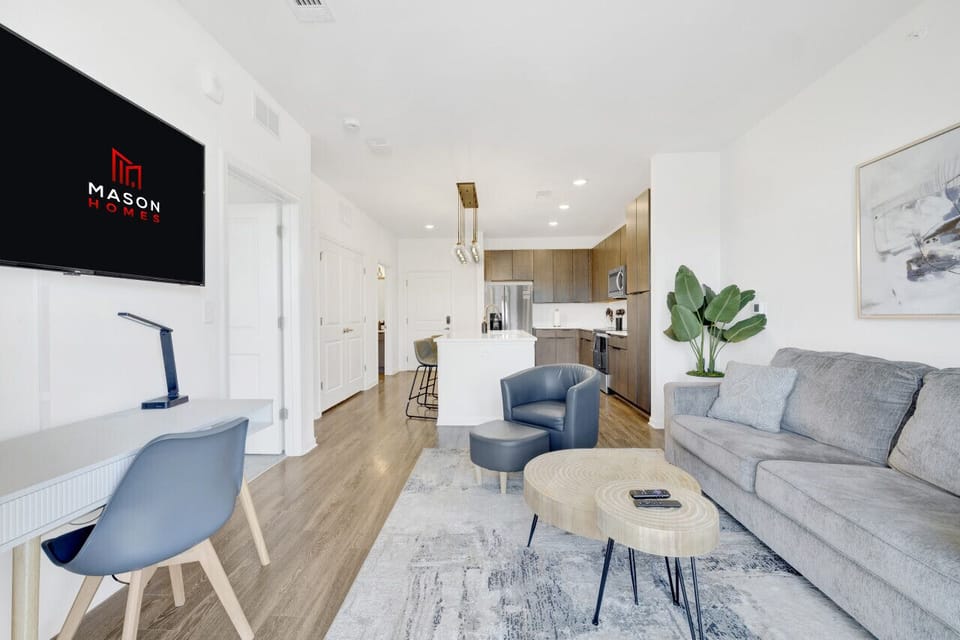 Relax in a stylish living area featuring a Smart TV and comfortable seating, perfect for unwinding during your short-term rental stay.