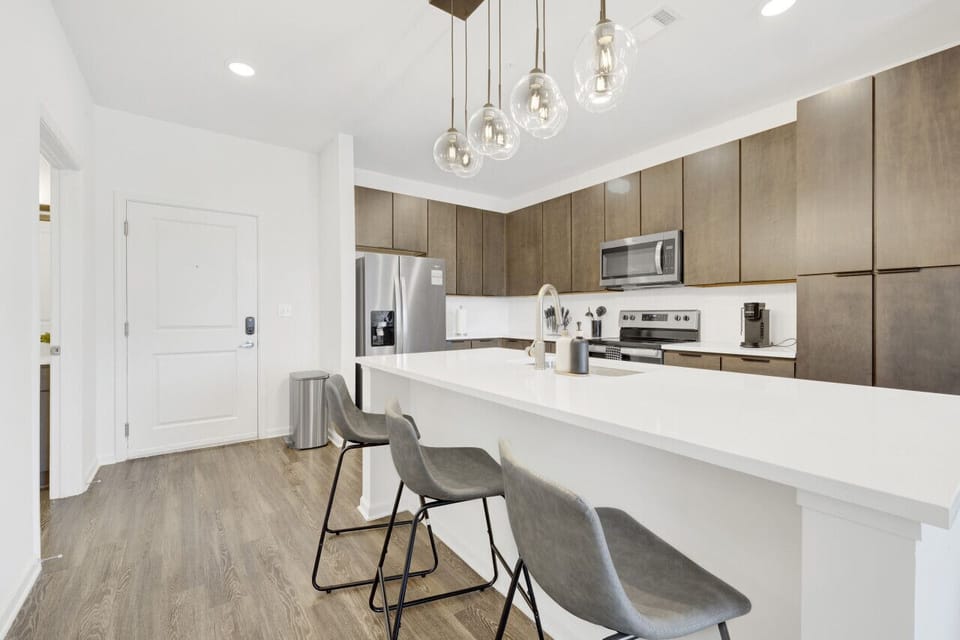 Modern kitchen with a sleek dining area, perfect for cooking, serving, and enjoying meals in style during your short-term rental stay