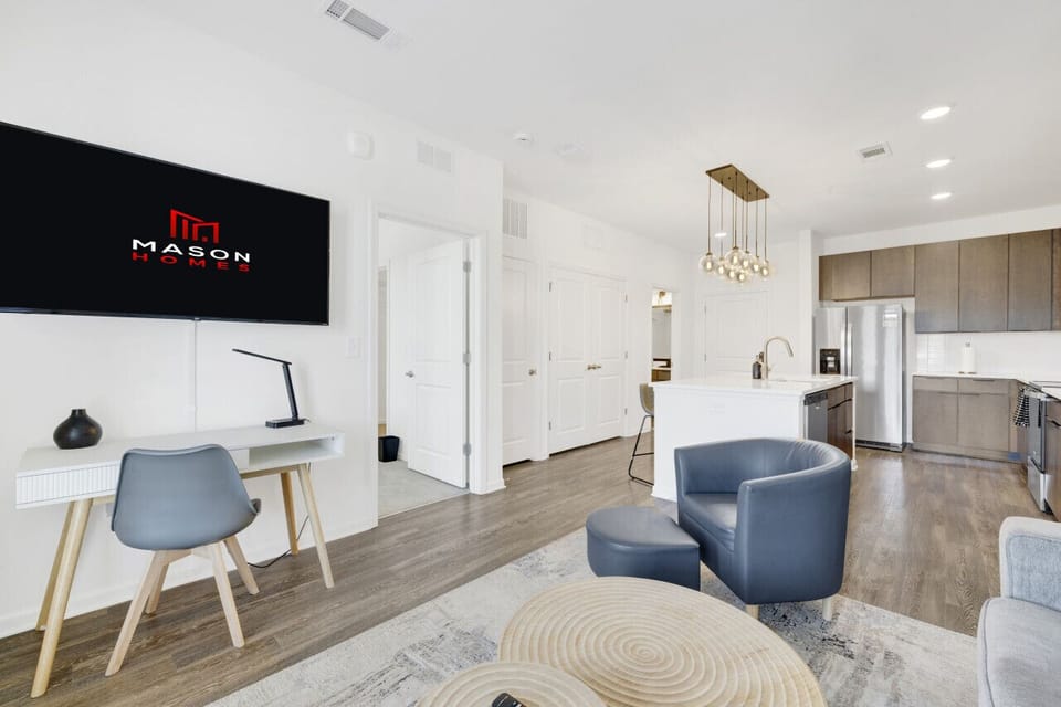 Relax in a stylish living area featuring a Smart TV and comfortable seating, perfect for unwinding during your short-term rental stay.