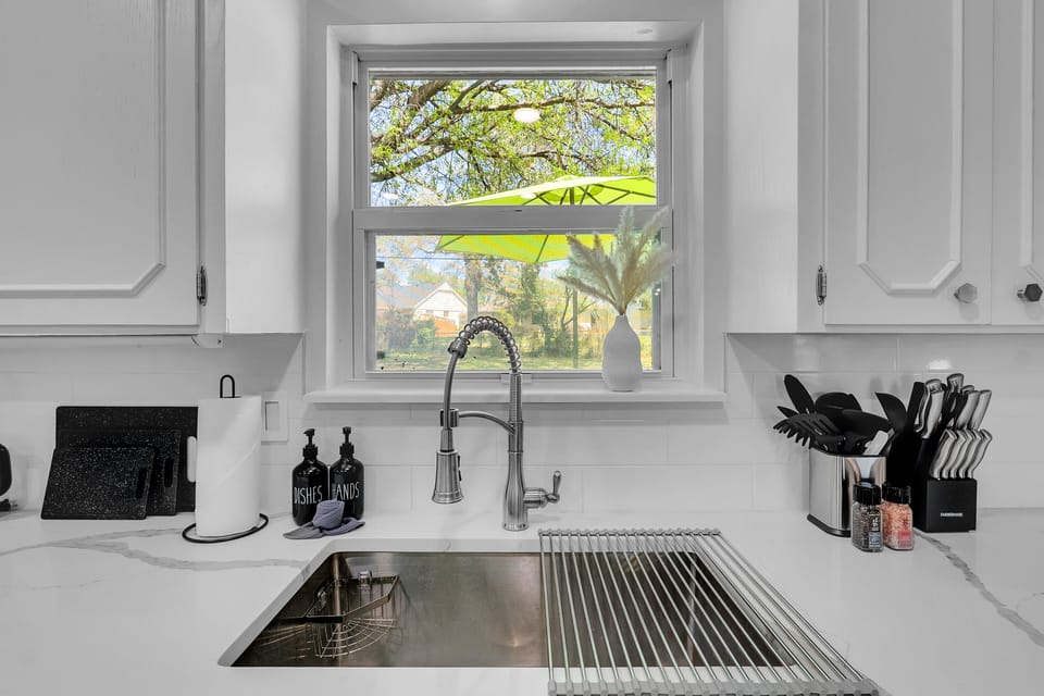 Discover culinary convenience with large sink accompanied by kitchenware.