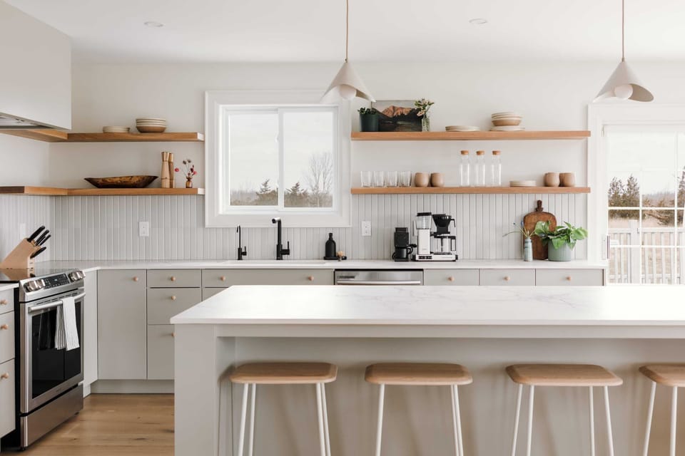 Beautiful open-concept kitchen equipped with handmade stoneware dishes and mugs, high-end cookware, spices, cast iron, crepe pan, coffee grinder and coffee maker (Fellow and Moccamaster)