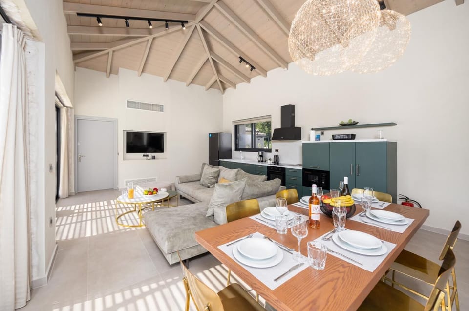 Open-plan living room with sofa, dining area, kitchen, A/C, WiFi internet, and satellite TV