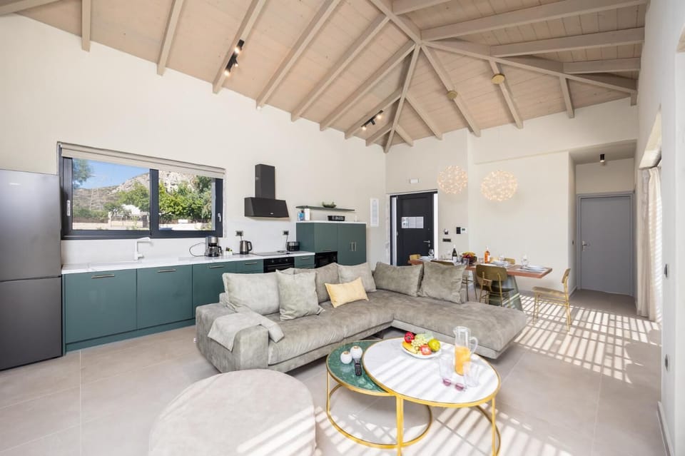 Open-plan living room with sofa, dining area, kitchen, A/C, WiFi internet, and satellite TV