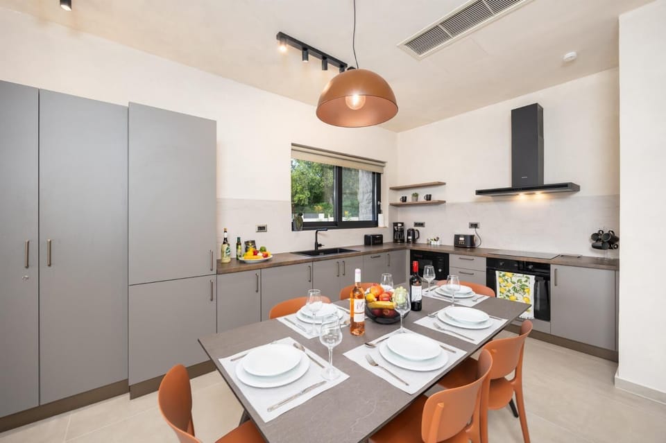 Open-plan living room with sofa, dining area, kitchen, A/C, WiFi internet, and satellite TV