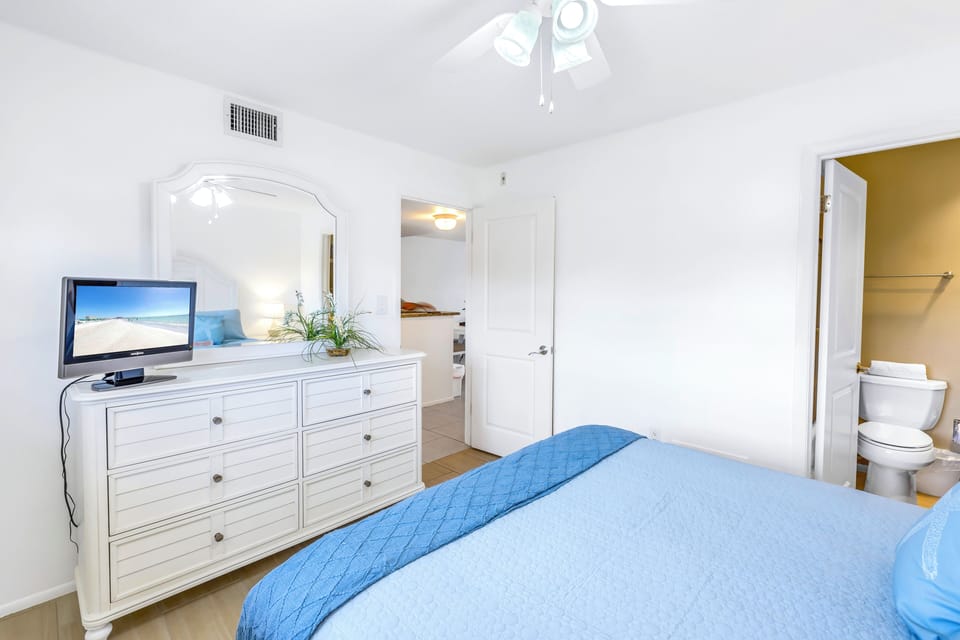 Queen bedroom with dresser and TV.