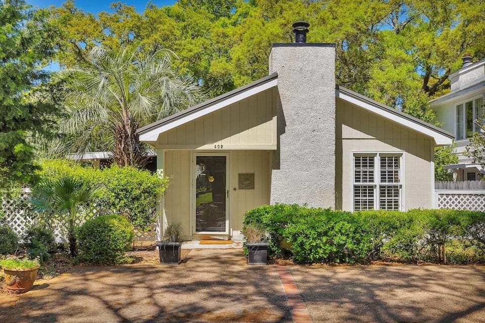 Front exterior with green landscaping and chimney