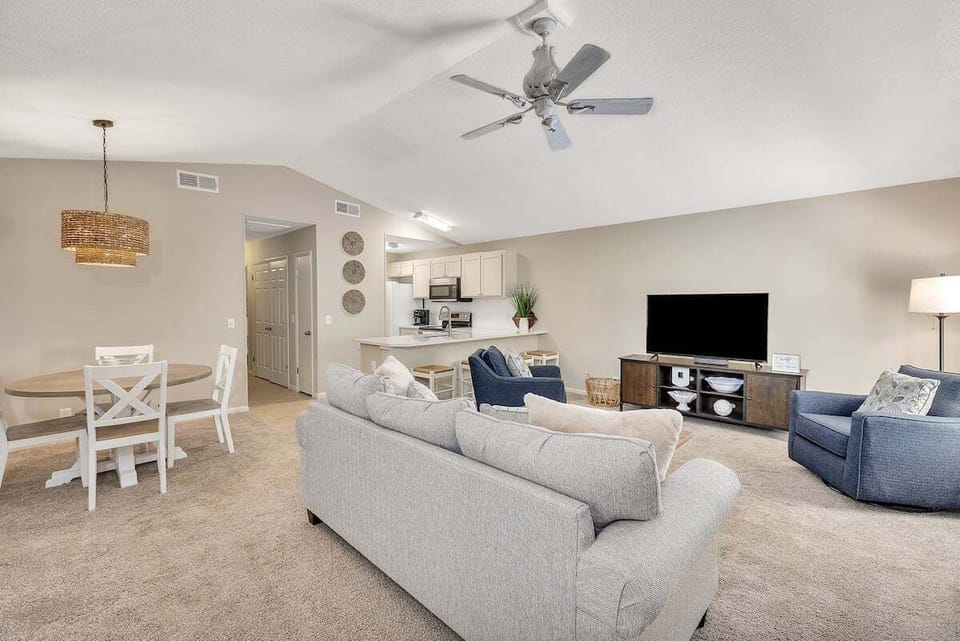 Spacious living area with vaulted ceiling and ceiling fan