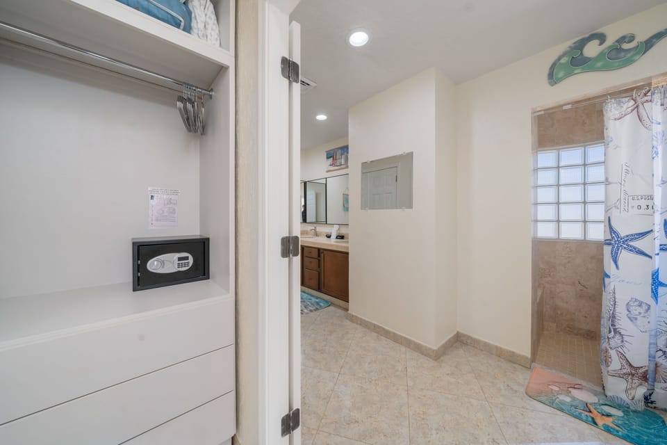 Refresh in the beautifully tiled walk-in shower with natural light filtering through the glass block window.