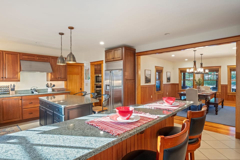 Fully equipped kitchen with granite countertops, breakfast bar seating, and plenty of space for cooking and gathering.