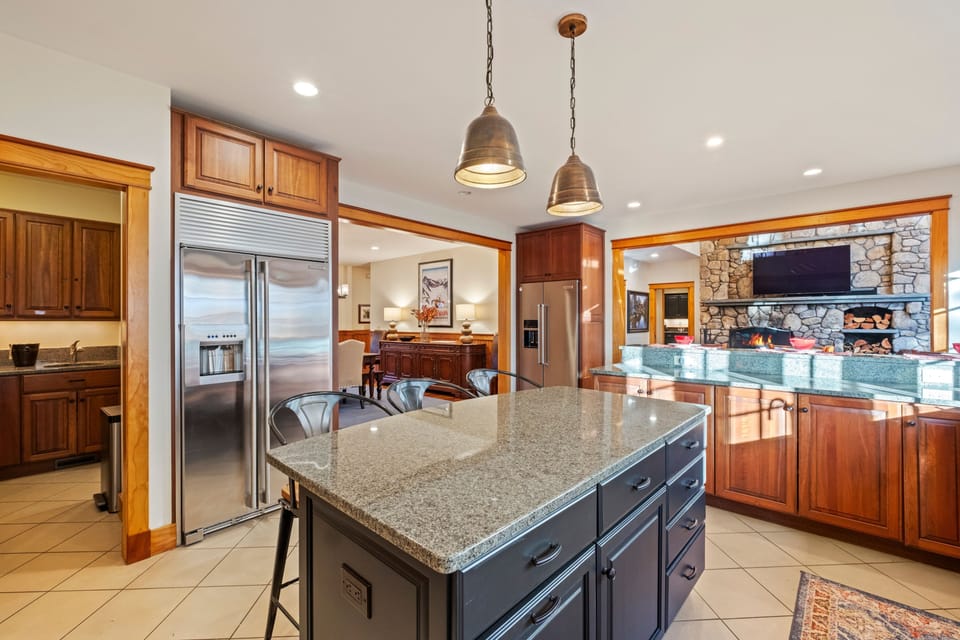 Fully equipped kitchen with granite countertops, breakfast bar seating, and plenty of space for cooking and gathering.