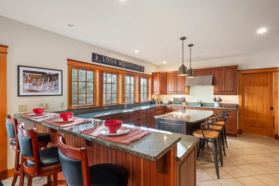 Fully equipped kitchen with granite countertops, breakfast bar seating, and plenty of space for cooking and gathering.
