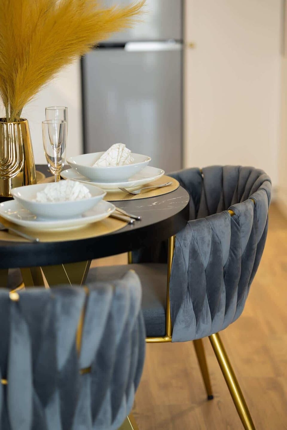 A close-up of an elegantly set dining table with luxurious blue and gold tableware.

