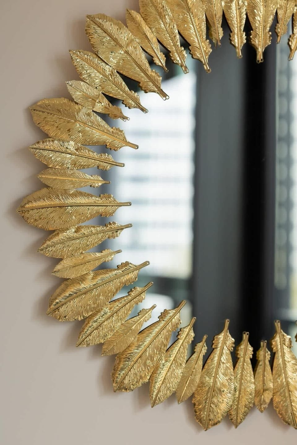 A decorative sunburst mirror with gold detailing, enhancing the luxurious aesthetic of the apartment.







