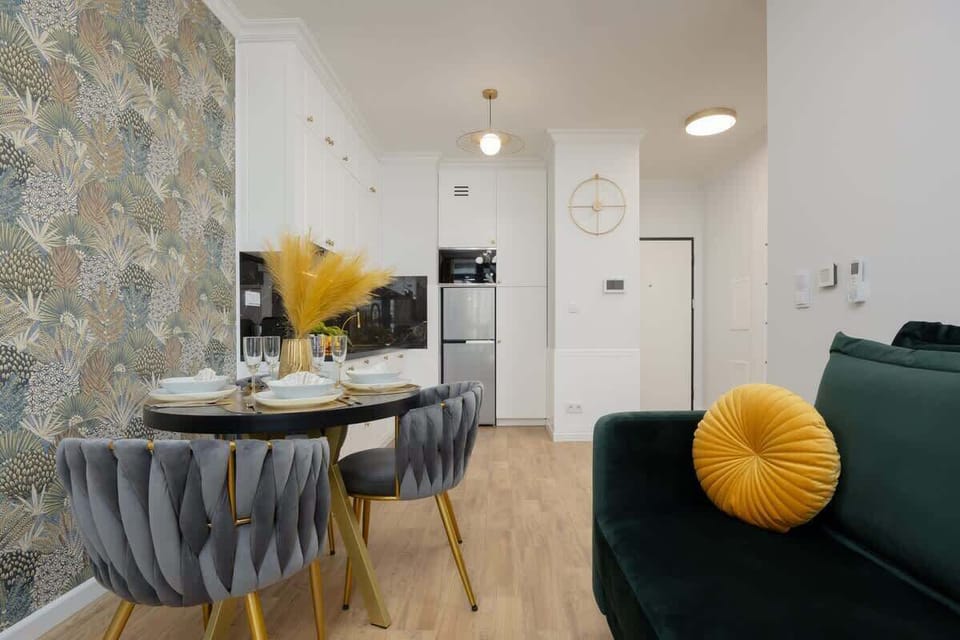 A full view of the open-plan kitchen and living space, featuring modern lighting and a cohesive color palette.


