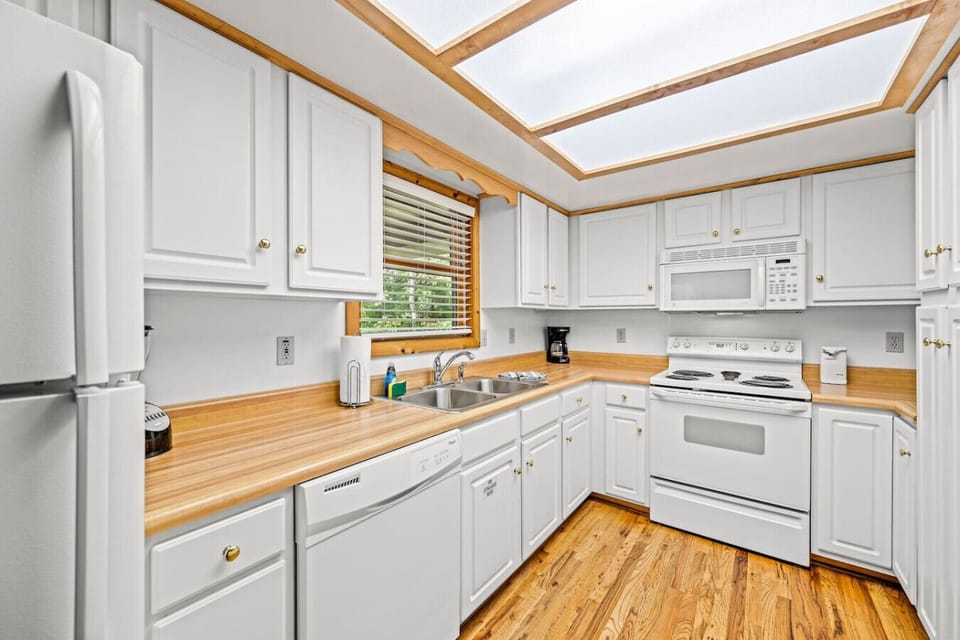 The kitchen includes a refrigerator, oven, stove, microwave, blender, coffee pot, and can opener as well as plates, dishes, bowls, cups, cookware, and more.