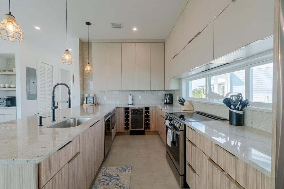 This stylish kitchen features custom cabinetry, stainless-steel appliances, abundant counters, and a convenient wine refrigerator.