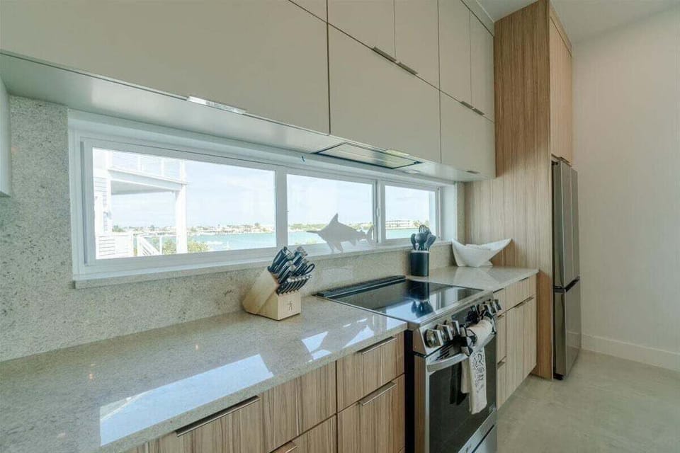 Prepare meals while enjoying natural light and canal views through a wall of windows above the kitchen counter.