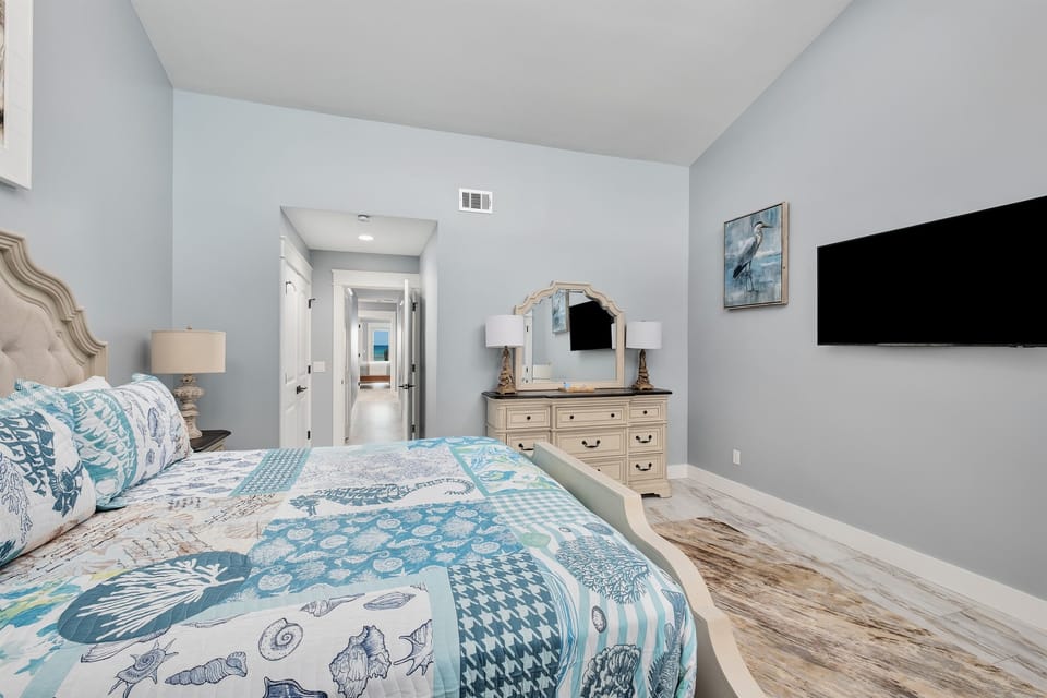 Relax in the bright and airy bedroom with large windows offering stunning ocean views.