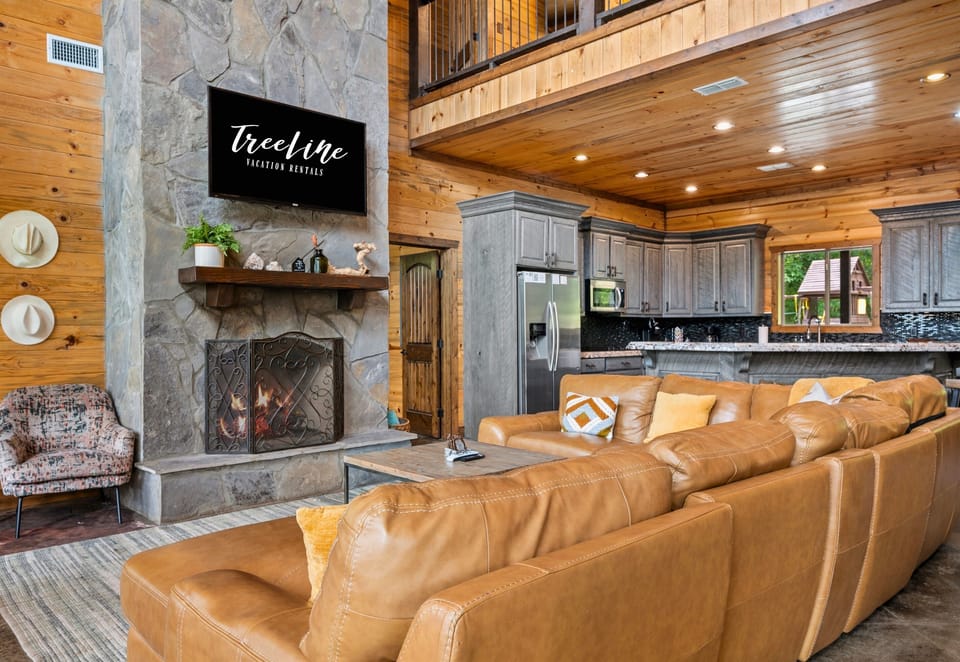 Double-height ceilings, cozy leather sectionals, and a show-stopping fireplace make this the heart of the home.